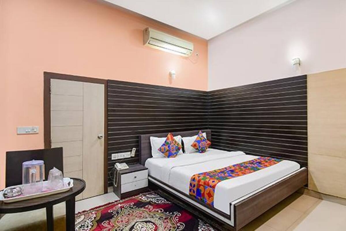 A bedroom with a bed, bedside table, and a small table with a tray.