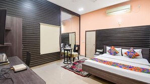 A modern bedroom with a bed, bedside table, and a desk with a chair. - FabExpress Gardenia (Kolkata)