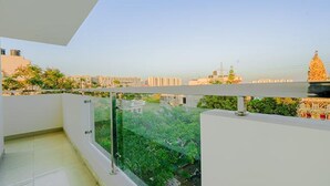 A balcony with a clear view of a cityscape, including buildings and a tree. - Fabhotel Phoenix Brookfield (Bengaluru)