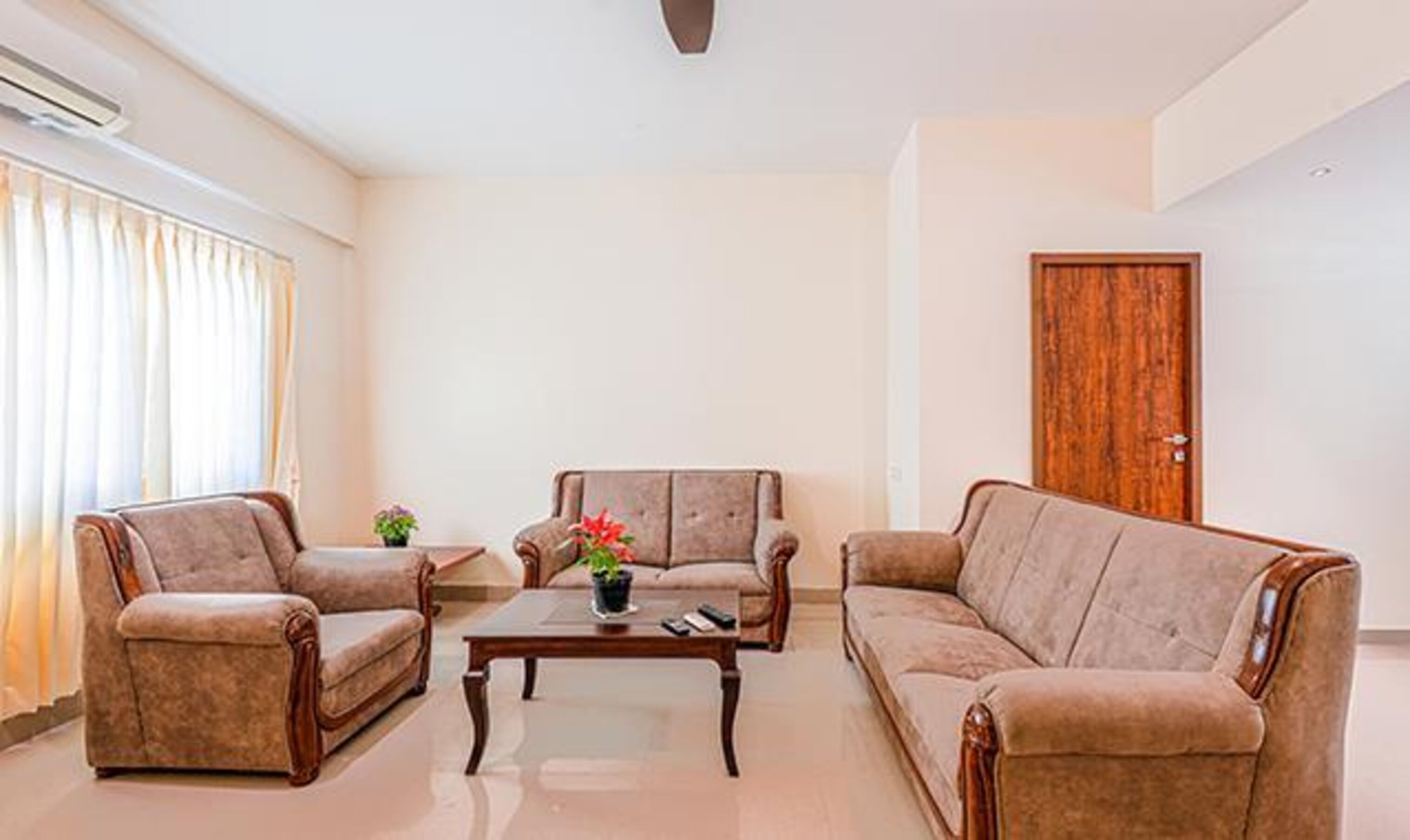 A living room with two sofas, a coffee table, and a wooden door.