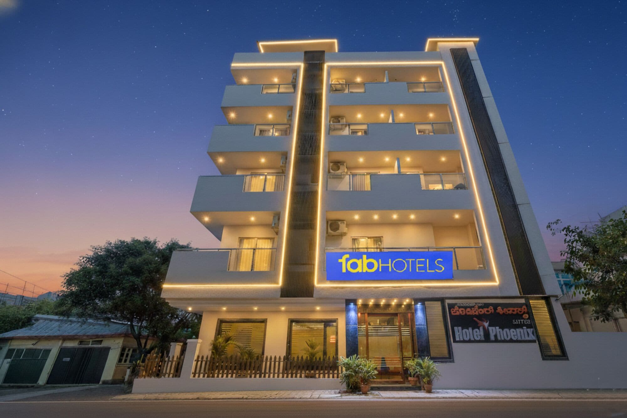A multi-story hotel with a modern facade, balconies, and a sign for 'fabHOTELS'.