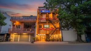 Un hotel chiamato 'The Shyam Inn' con un balcone, delle scale e un cartello con la scritta 'Fab Hotels'.