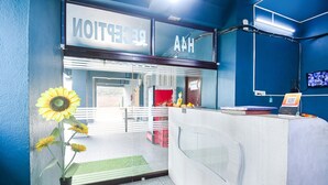 A reception area with a blue wall, a reception desk, and a sign that reads "Reception." - Fabhotel Silverkey (Barasat)