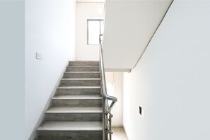 Una escalera con barandilla metálica que lleva a una plataforma.