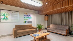 Eine moderne Lobby mit zwei Sofas, einem Couchtisch und einem Topfpflanzen.