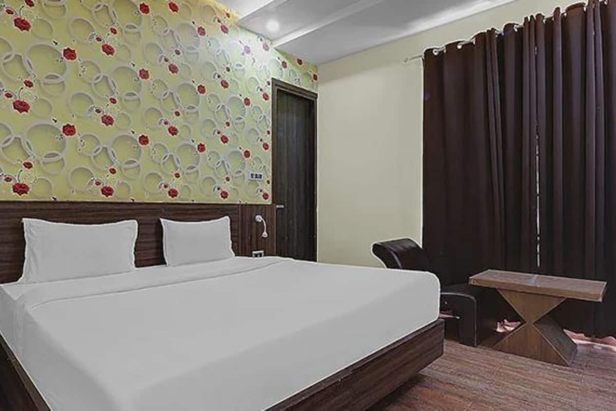 Habitación de hotel con una cama grande, un escritorio y una silla.
