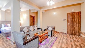 Un salon moderne avec un canapé, des fauteuils, une table basse et un tapis à motifs.