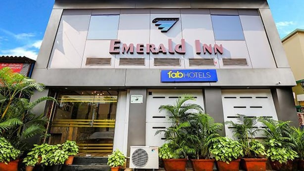 The exterior of Emerald Inn, featuring a modern facade with large windows and a prominent logo. - Fabexpress Emerald Inn (Mumbai)