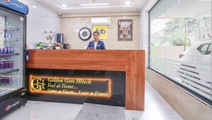 Ein Hotelrezeptionstresen mit einem Kühlschrank für Pepsi, einer Uhr und einem Schild mit der Aufschrift 'fab hotels'.