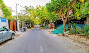 Una calle con coches aparcados y árboles a lo largo de la calzada.
