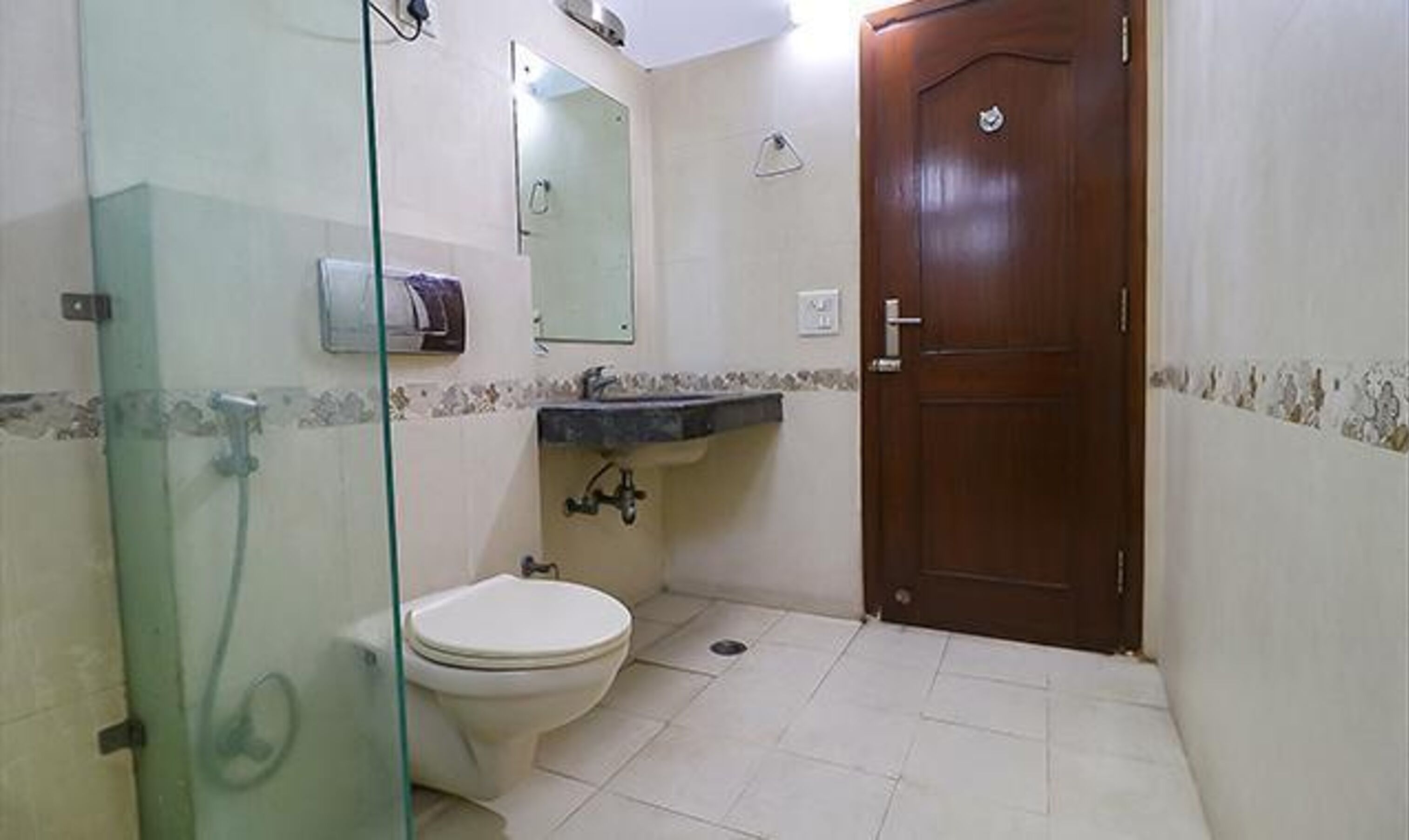 Un baño pequeño con inodoro, lavamanos y ducha.