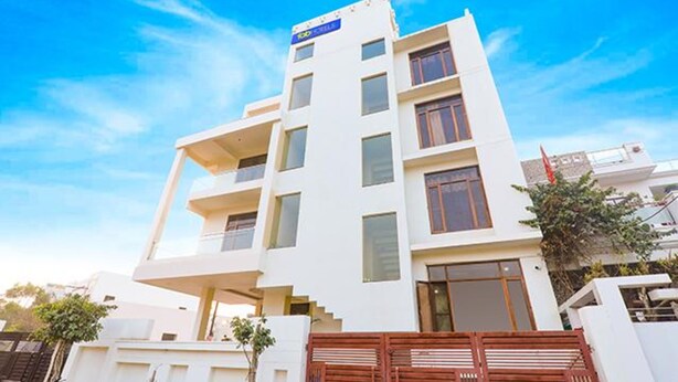 A multi-story building with a flat roof, large windows, and a sign indicating it is a hotel. - FabHotel The Gahmar Inn (Lucknow)