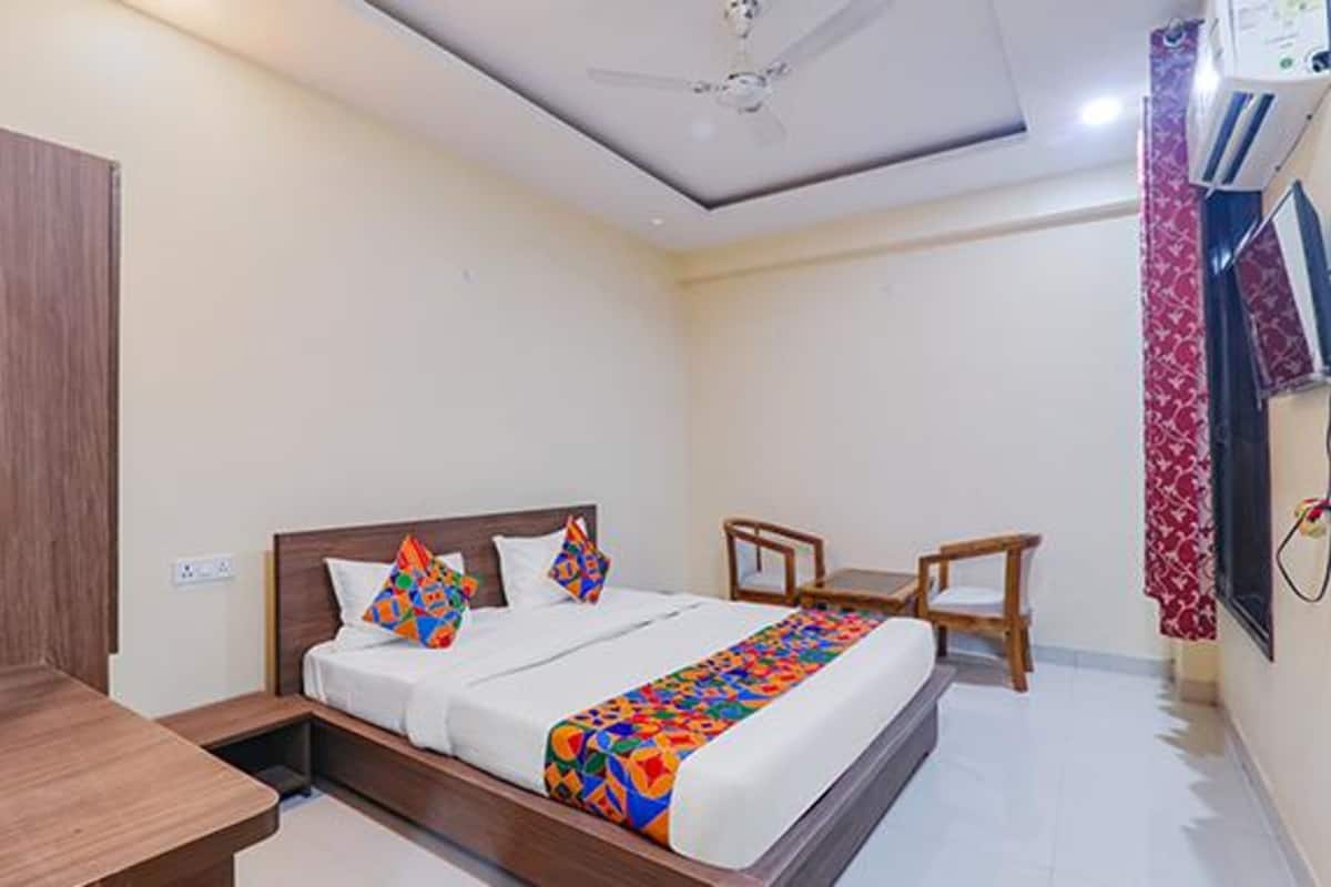 A hotel room with a bed, bedside tables, a wardrobe, and a ceiling fan.