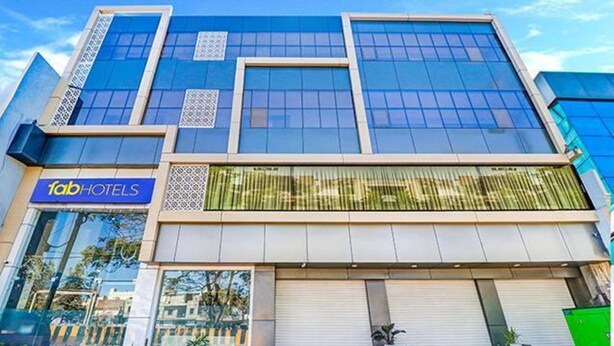 A modern hotel facade with a large glass window and a sign for 'fabHOTELS'. - Fabhotel Meera Palace (Indore)