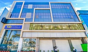 Fachada d'un hotel modern amb un gran finestral i un rètol que diu 'fabHOTELS'.