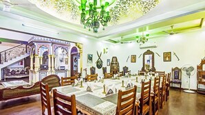 Comedor con una mesa larga dispuesta para varias personas, rodeada de sillas de madera.