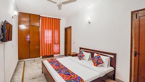 A bedroom with a bed, a ceiling fan, and a TV on the wall. - FabHotel Goodwill Homes (New Delhi)