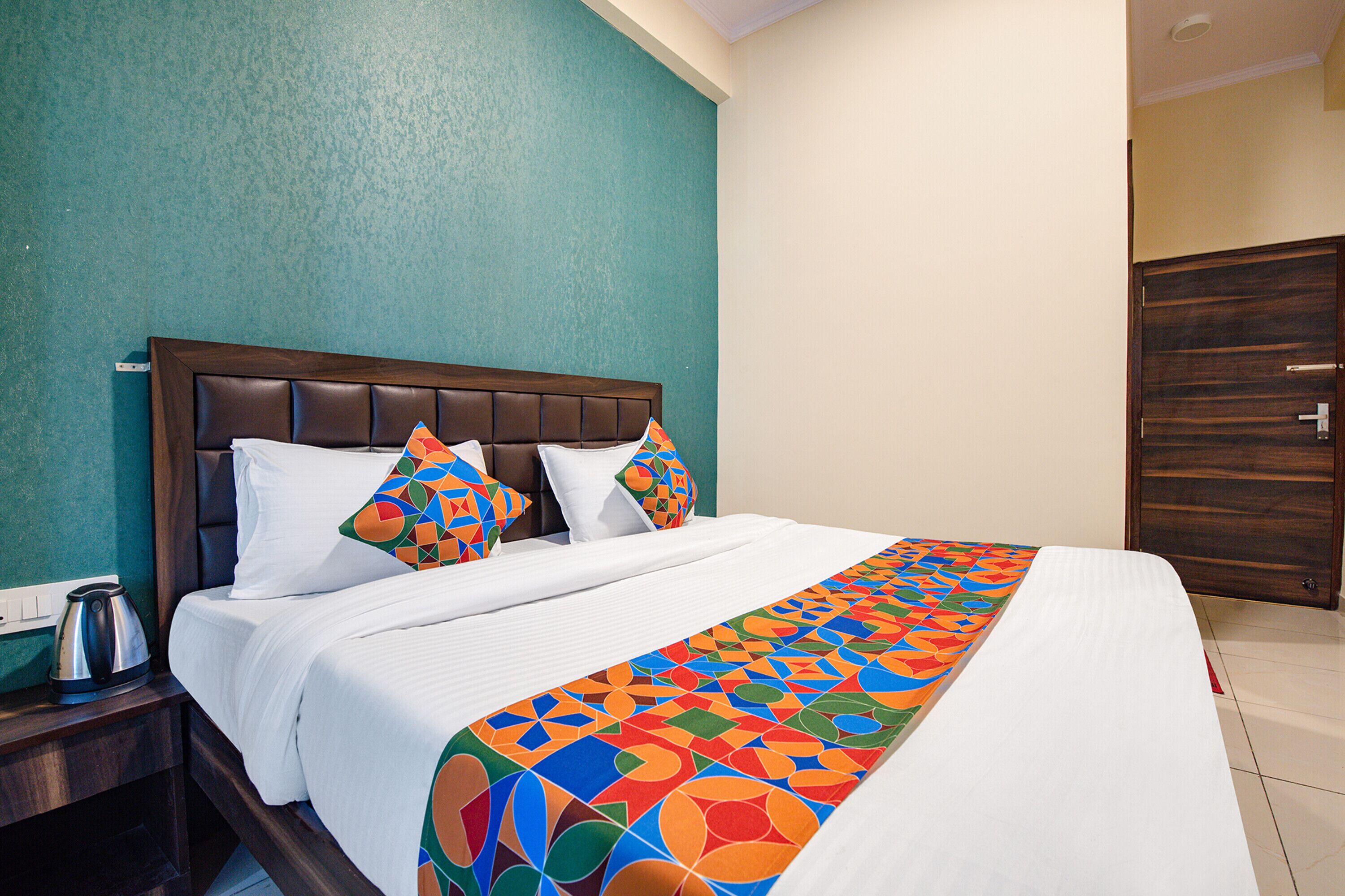 A hotel room with a bed, a nightstand, and a wardrobe.