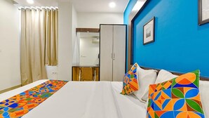 Una habitación de hotel con cama, escritorio y armario.