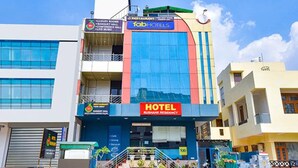 Un edificio de varios pisos con un llamativo letrero de 'fab hotels', señalización de 'hotel' y un rótulo de 'Rushank Residency'.
