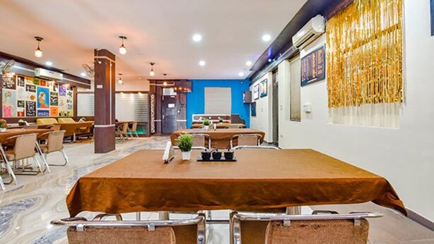 Un salón de conferencias con una larga mesa, sillas y una pared azul decorativa.