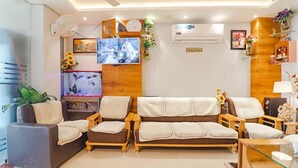 Uma sala de estar com um sofá, um aquário e objetos decorativos.