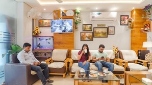 Uma sala de estar moderna com sofás, uma mesa de centro e uma televisão.