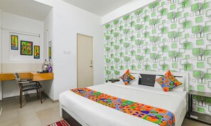 Een slaapkamer met een bed, een bureau en een stoel.