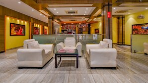 A lobby with white leather sofas, a reception desk, and artwork on the walls. - Fabhotel Wind Palace (Jaipur)