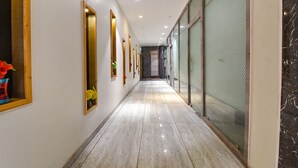 A hallway with a polished marble floor, wooden-framed mirrors, and a glass door on the right. - Fabhotel Wind Palace (Jaipur)