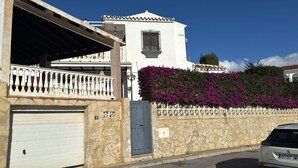 A white building with a stone facade, a balcony with white balustrades, and a blue door. - Villa - Casa del Sol! Detached villa with pool, outdoor terraces near the beach! (Nerja)
