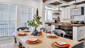 A dining area with a wooden table set for six, surrounded by white cabinets and a kitchen area with a wooden ceiling. - 30A Santa Rosa Beach 3mi to Private Beach and Mall (Santa Rosa Beach)