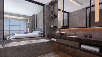 A modern bathroom with a large mirror, a bathtub, and a vanity with a sink.
