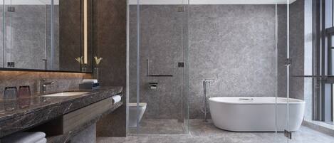 A modern bathroom with a glass-enclosed shower, a freestanding bathtub, and a marble countertop.