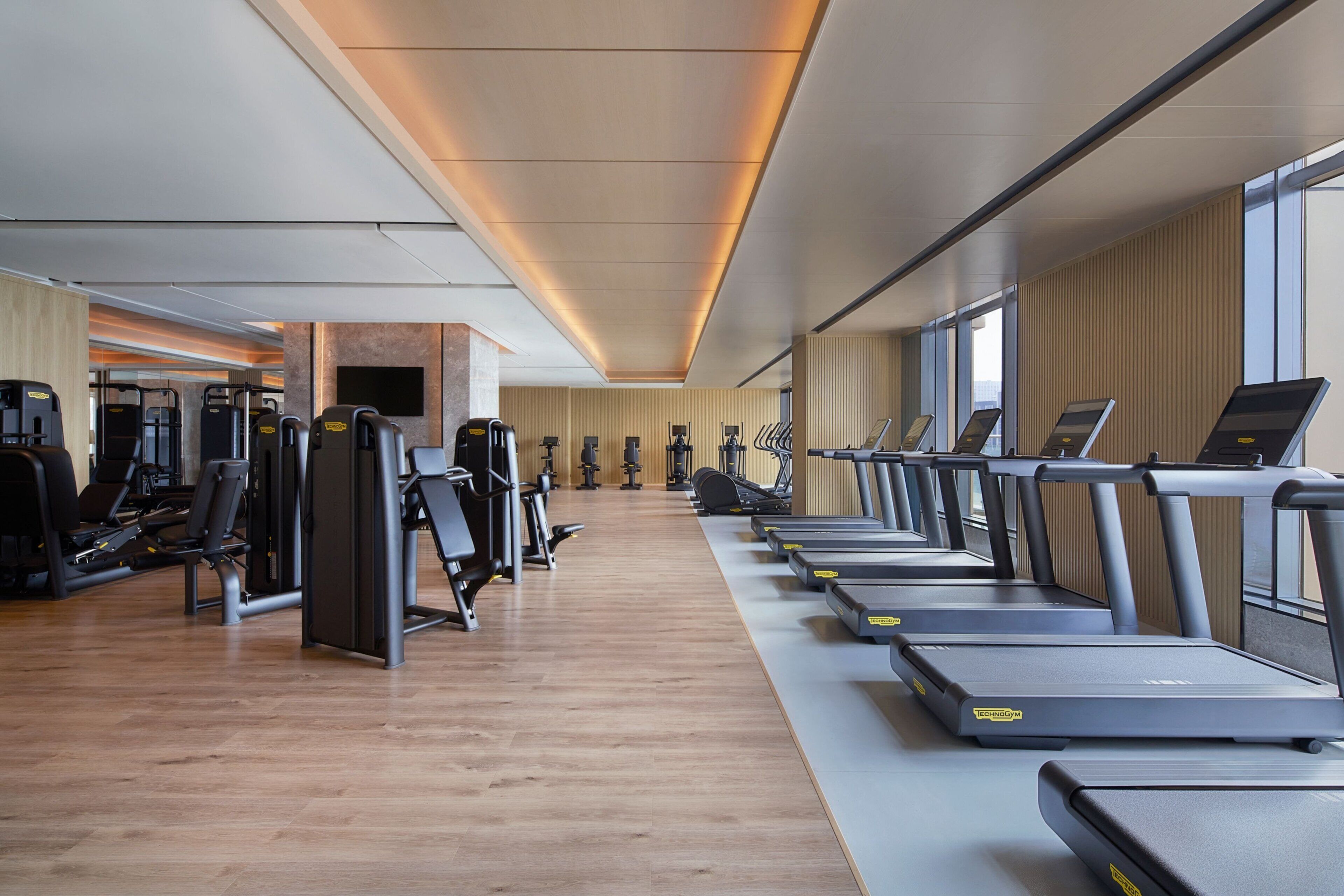 Une salle de sport équipée de tapis de course, d’appareils de musculation et d’autres équipements d’exercice.