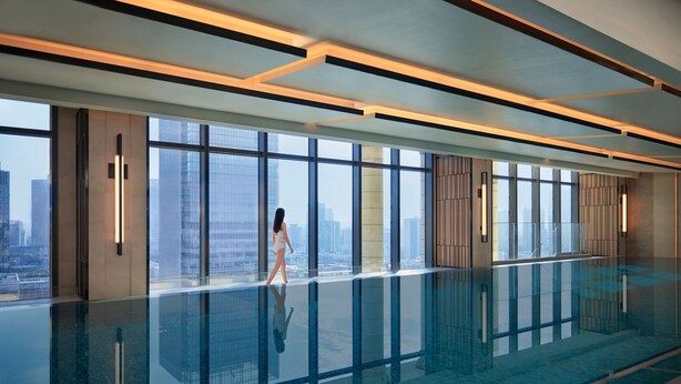 A modern indoor pool with large windows offering city views. - Foshan Marriott Hotel (Foshan)