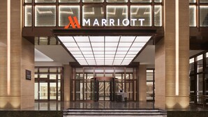 A Marriott hotel entrance with a glass facade, a revolving door, and a tiled roof. - Foshan Marriott Hotel (Foshan)