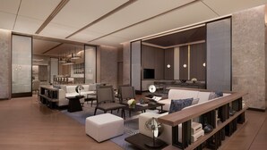 A modern living room with a sofa, chairs, a coffee table, and a TV. There is a kitchen area in the background. - Foshan Marriott Hotel (Foshan)