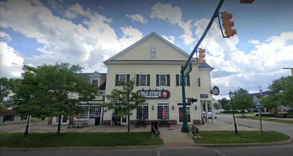 A white building with a sign reading "Cold Stone."