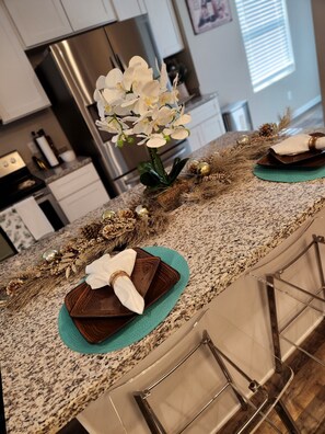 Enjoy cooking in this well-equipped kitchen with a granite countertop, featuring a stove and refrigerator.