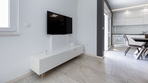 A modern kitchen with white cabinetry, a built-in oven, and a dining area with a table and chairs. - Holiday Home Miriam Kastela With a Private Pool (Kastela)