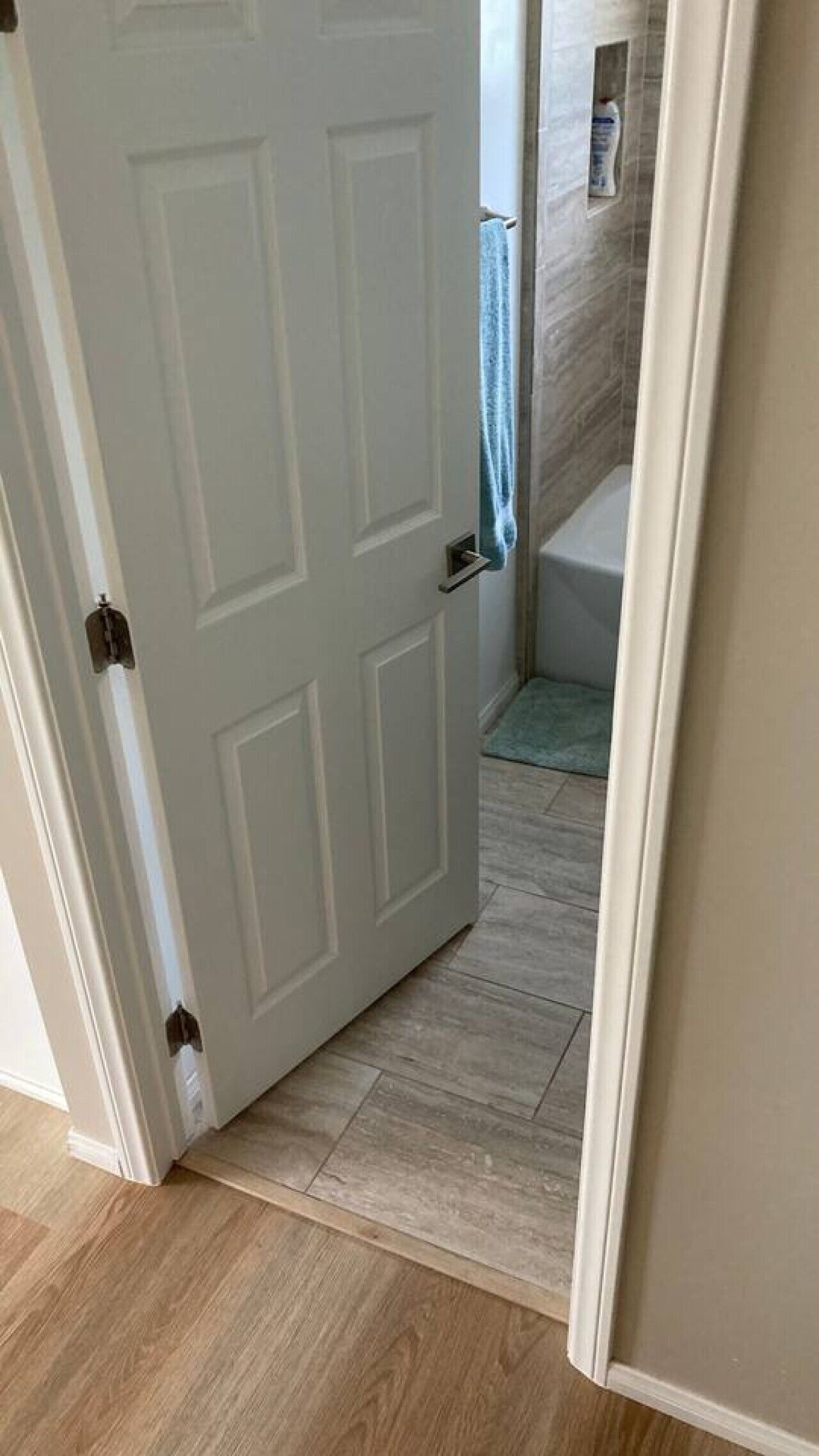 A bathroom with a bathtub, a towel rack, and a shower area.