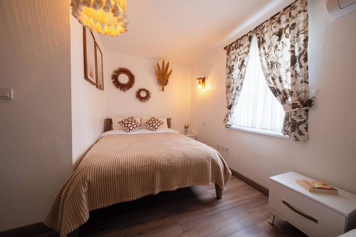A bedroom with a bed, bedside table, and a nightstand.