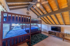 A room with two bunk beds, a television, and a wooden ceiling. - Large and Comfortable Condo w/ Loft (Mammoth Lakes)