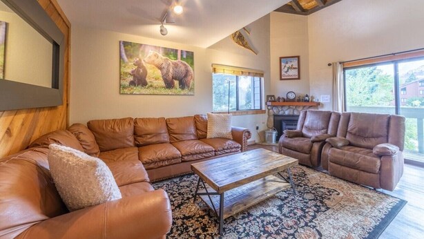 A living room with a sectional sofa, a recliner, a coffee table, and a fireplace. - Large and Comfortable Condo w/ Loft (Mammoth Lakes)