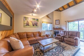 A living room with a sectional sofa, a recliner, a coffee table, and a fireplace.