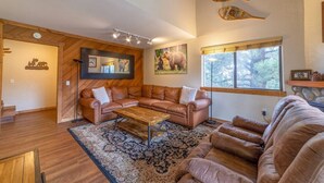 A spacious living room with a large brown leather sofa, a wooden coffee table, and a patterned rug. - Large and Comfortable Condo w/ Loft (Mammoth Lakes)