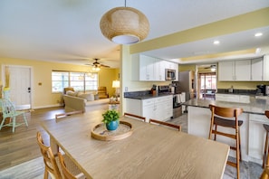 Enjoy a bright and inviting kitchen and dining area with a clean design, featuring a wooden table and stainless steel appliances.