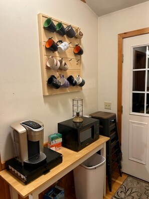 Compact kitchen with a coffee maker, microwave, and refrigerator.