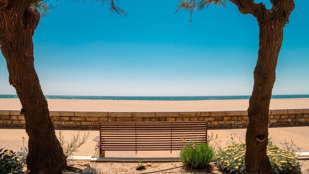 A bench with a stone wall and a clear view of the beach and ocean. - Serignan-Canal du midi. Spacious apartment in luxury apartment complex. Full A/C (Sérignan)